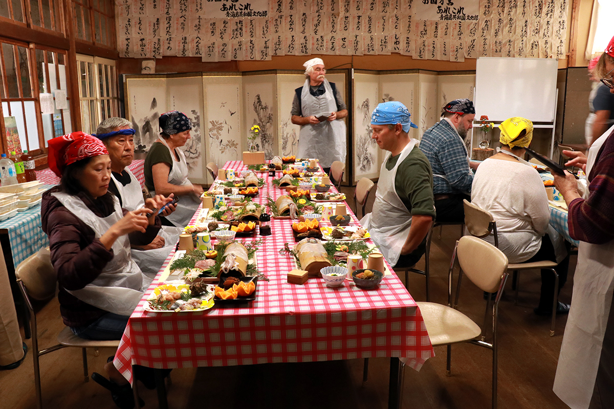▲「魚さばき体験」の後の食事風景。さばいた魚だけでなく、地元の食材をふんだんに使った料理もたくさん振舞われる。